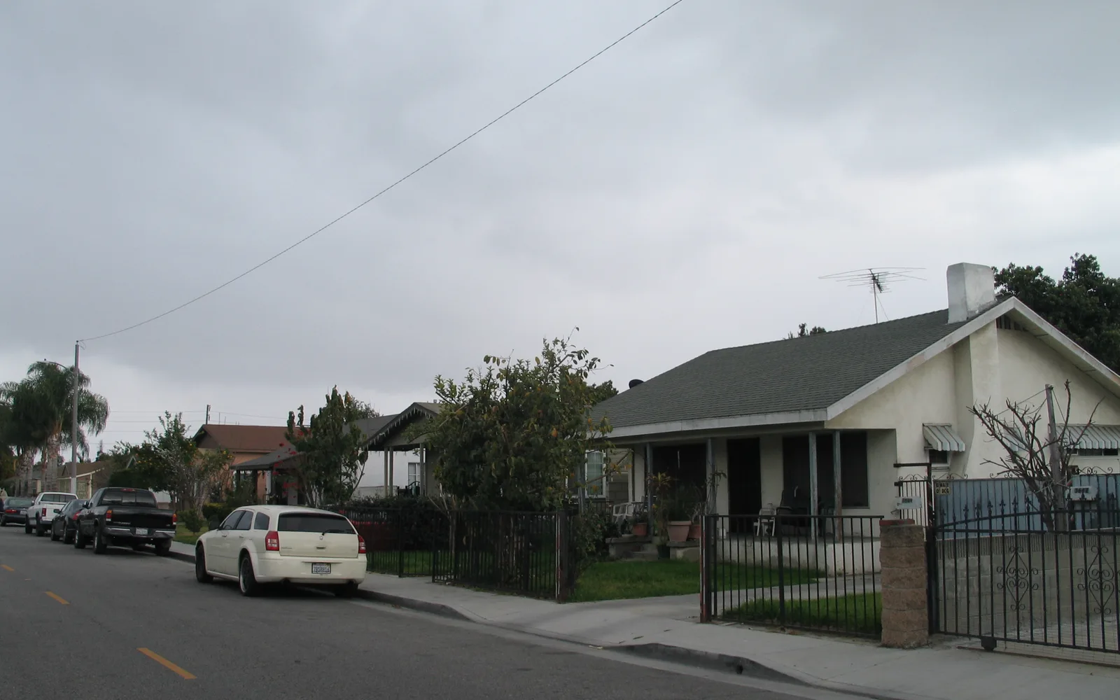 Residential street in Lynwood California showing single-family homes, parked vehicles, and tree-lined street typical of suburban neighborhoods